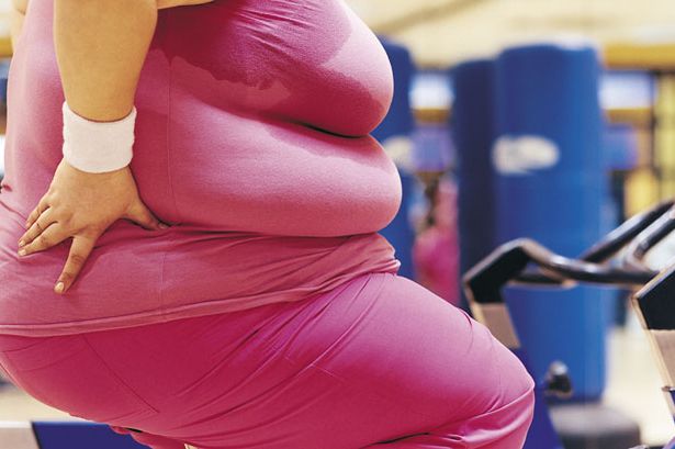 Fat woman exercising in gym